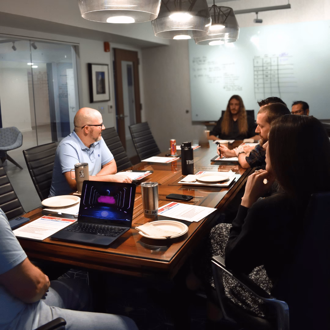 Team of IT professionals in a meeting collaborating around a conference table.